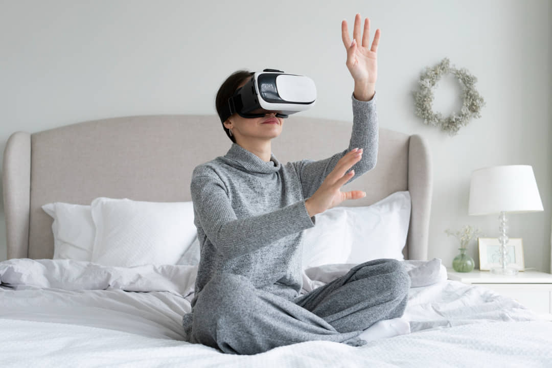 Imagen de una mujer utilizando la realidad virtual para el sector hotelero.